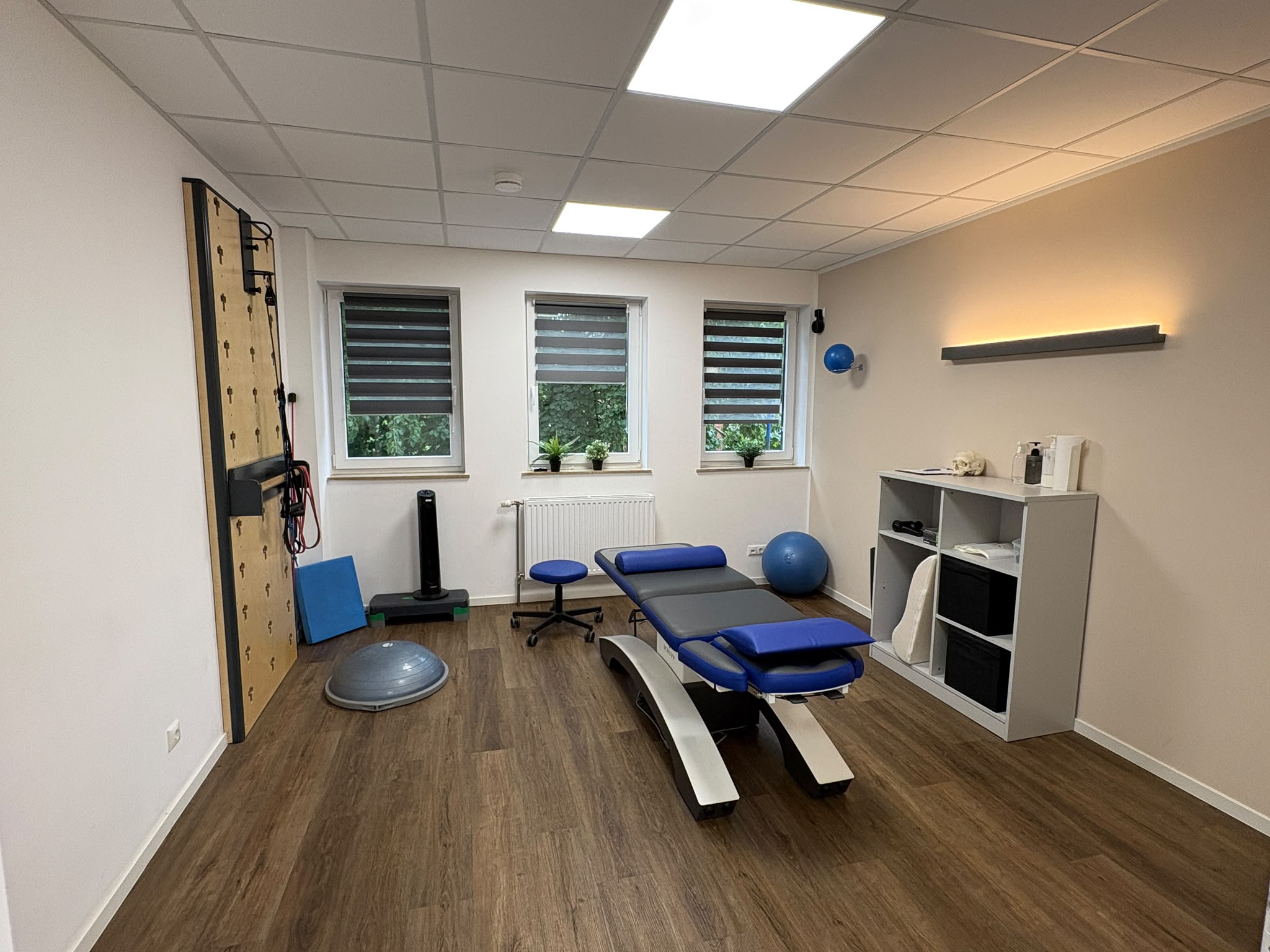 Physiotherapeutischer Behandlungsraum mit Therapieliege und Trainingswand